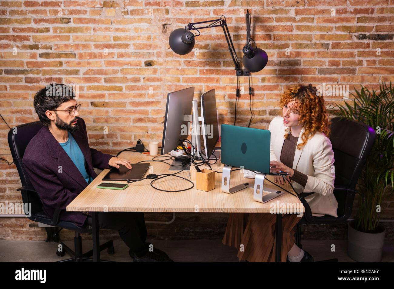 Designers working together on computers in modern office Stock Photo
