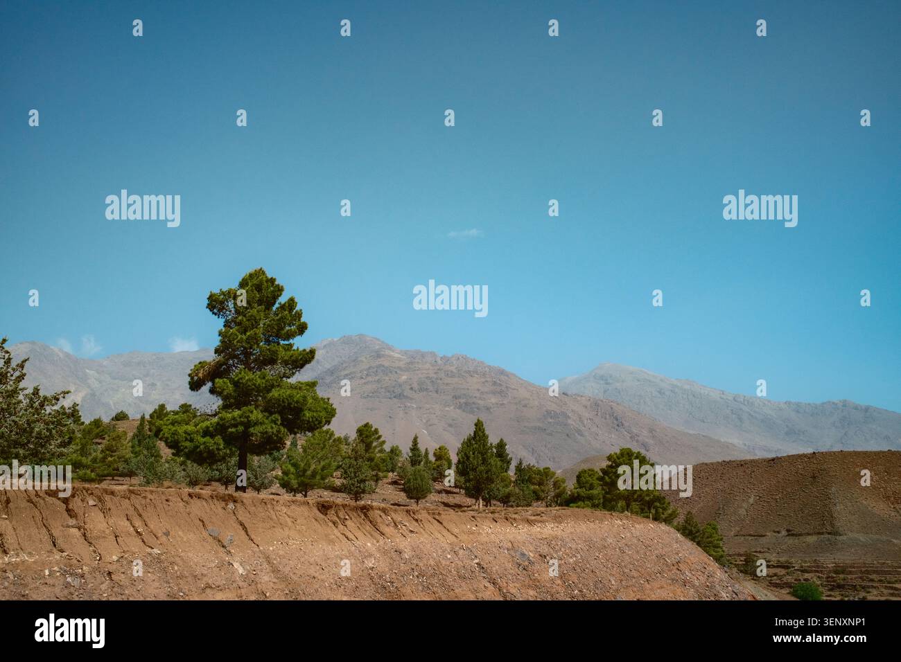 Dry Hillside Under Clear Blue Mountain Sky Stock Photo