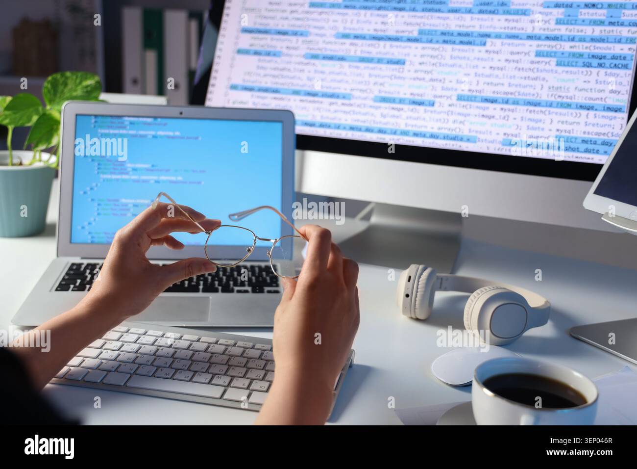 Female programmers hands with eyeglasses at table in office, closeup Stock Photo