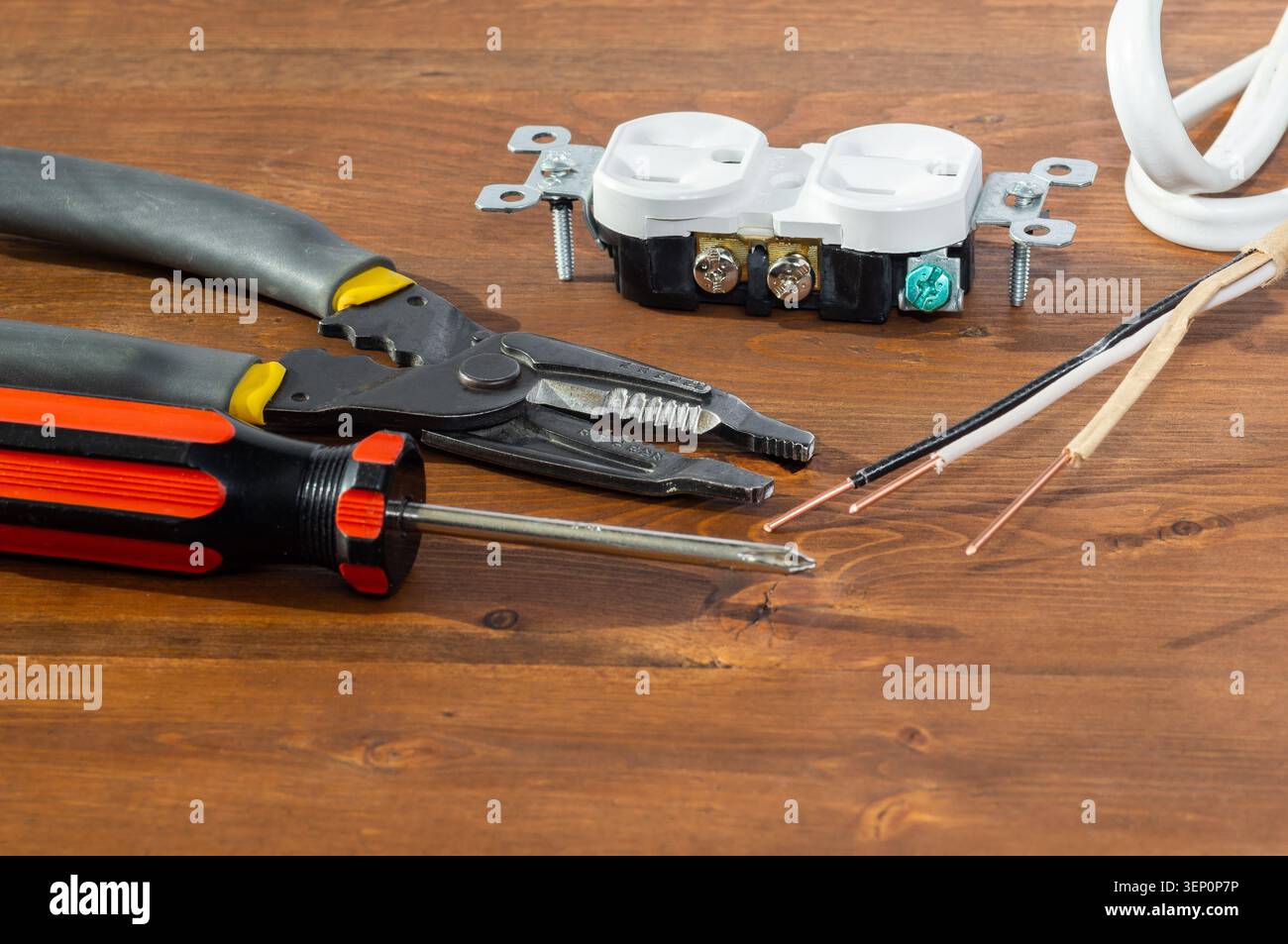 Electrical outlet, screwdriver and wire stripper tools on white background Stock Photo