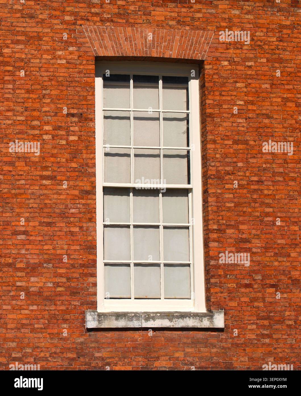 Single wooden multi framed window in a red brick wall Stock Photo