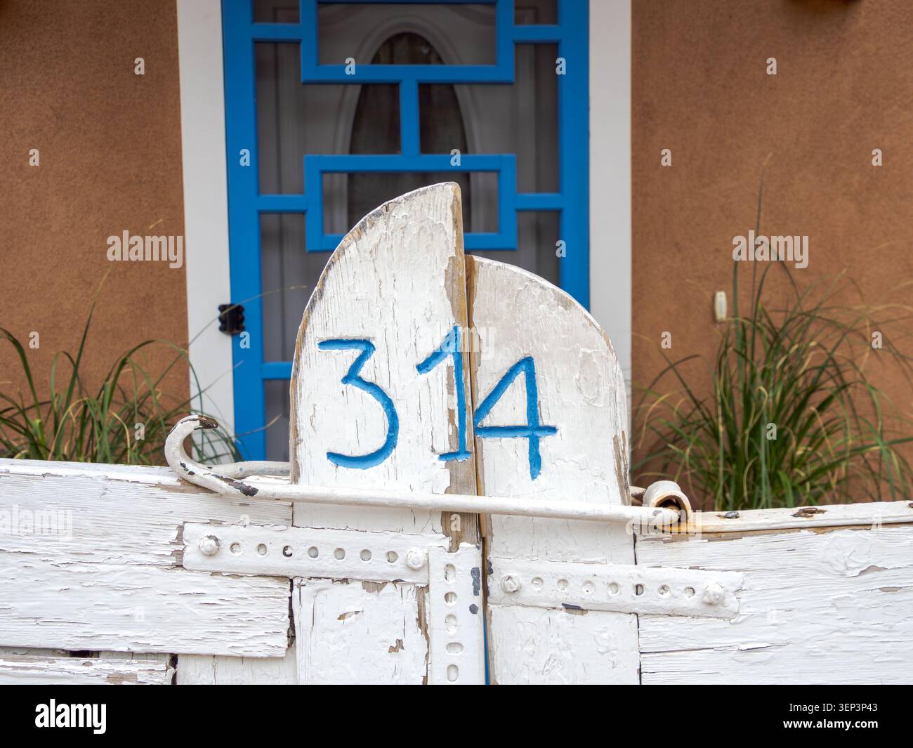 Santa Fe, NM - May 6 , 2026 - The number 314 painted in blue on a white wooden gate makes an interesting abstract image Stock Photo