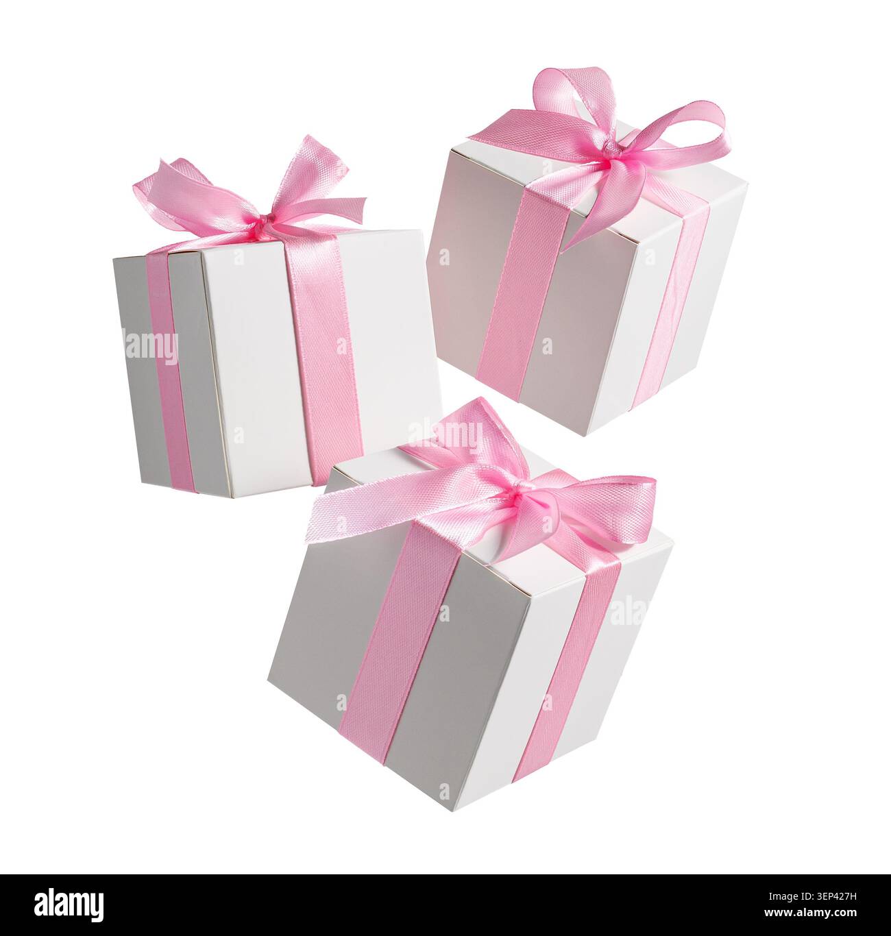 White gift boxes with pink bows flying and falling isolated on white background Stock Photo