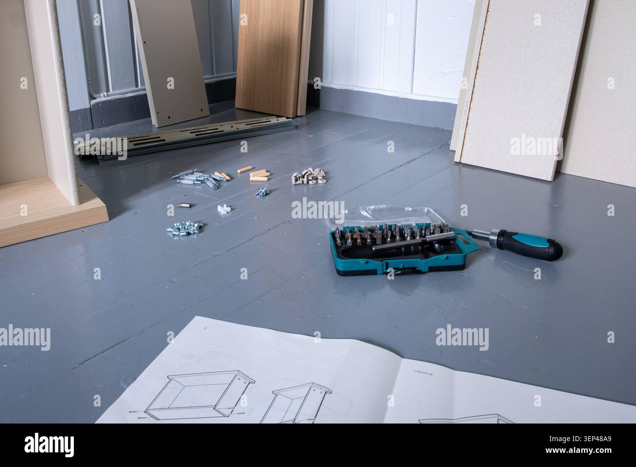 Furniture assembly project with instruction manual, tools, hardware and furniture components prepared for installation Stock Photo