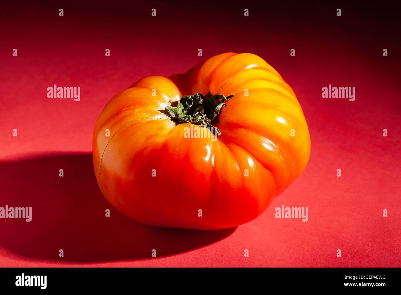 heirloom tomato on red background Stock Photo