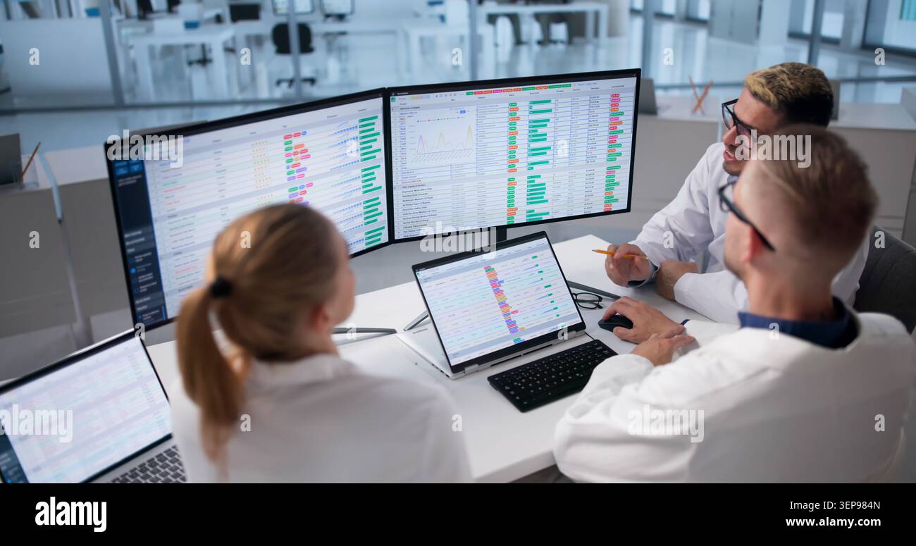 Medical Billing Team Works Together Reviewing Coding Data On Computer. Stock Photo
