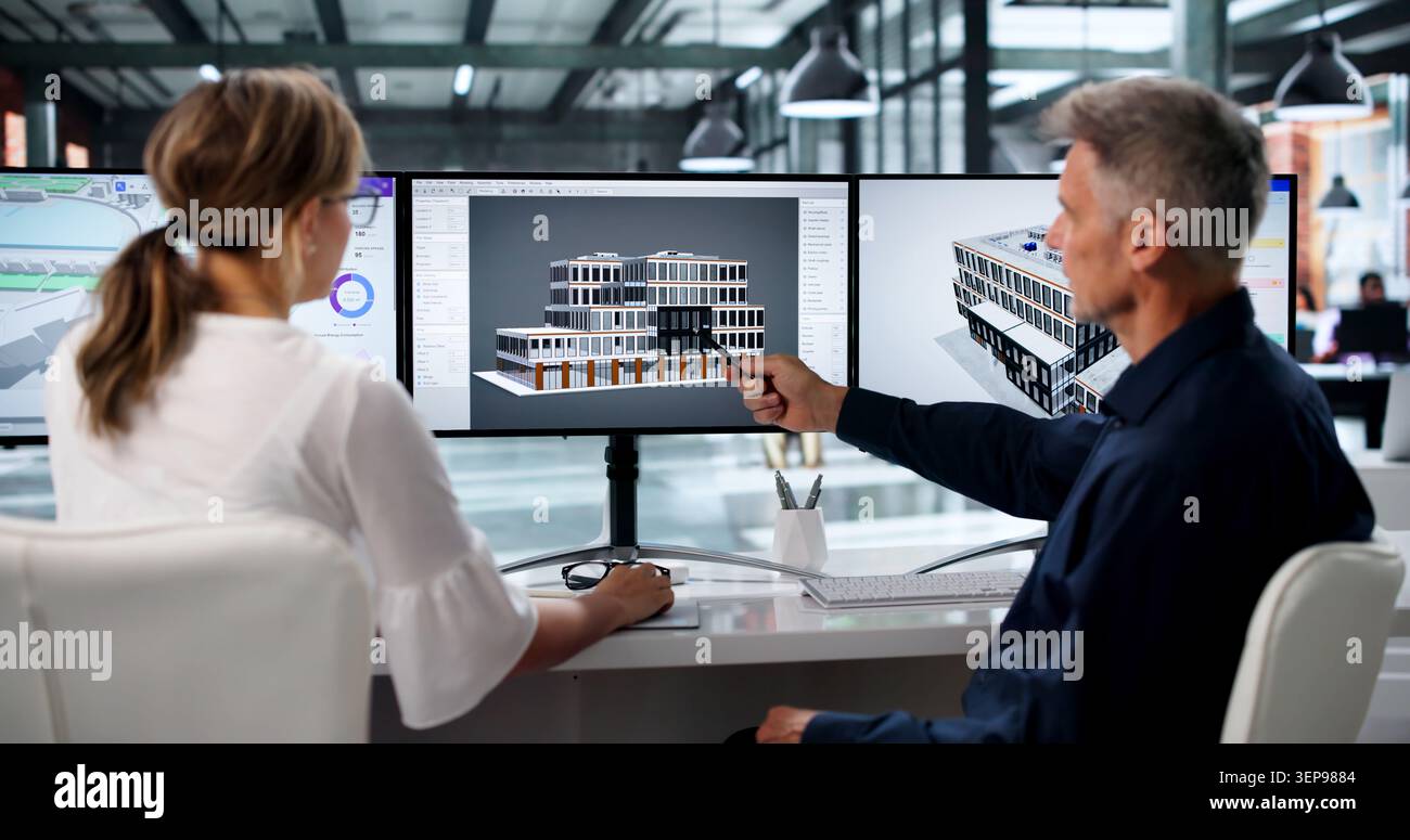 Two Engineers Discuss 3D Building Plans Using BIM Software On Screen. Stock Photo