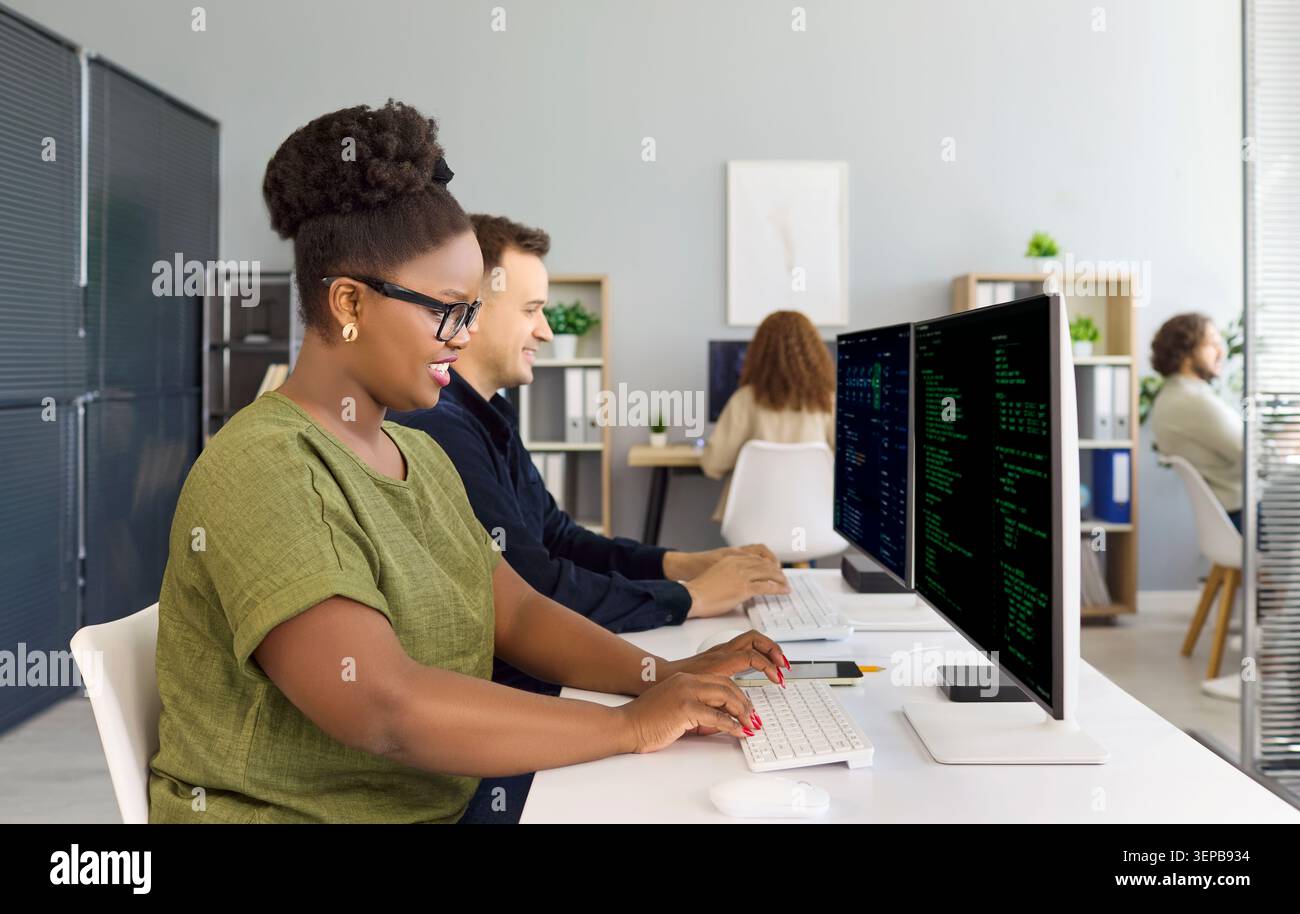 Developers coding at computers in office with programmers teamwork for startup Stock Photo