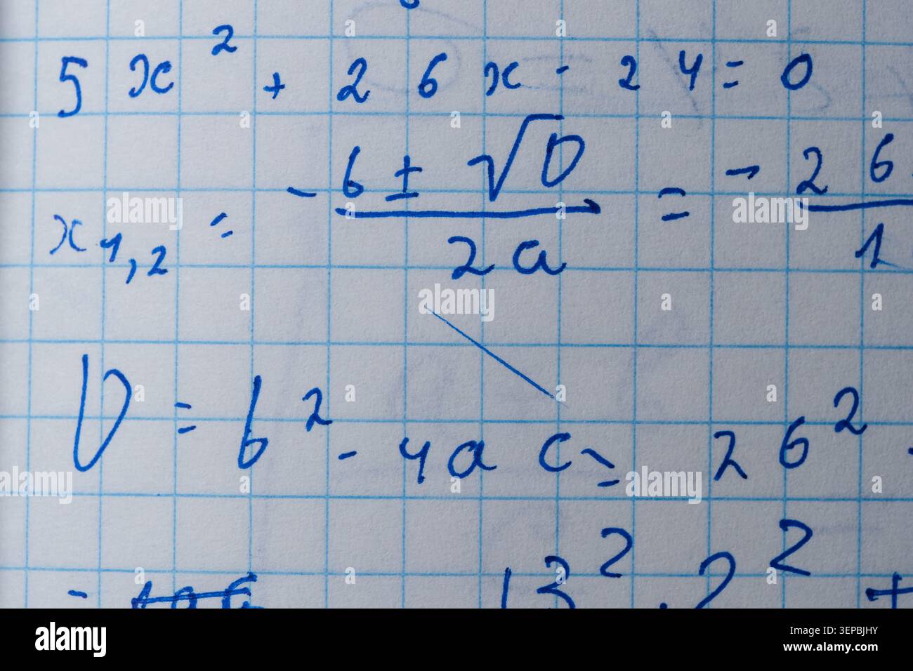 Notes show steps to solve quadratic equations in a cozy classroom setting. Stock Photo