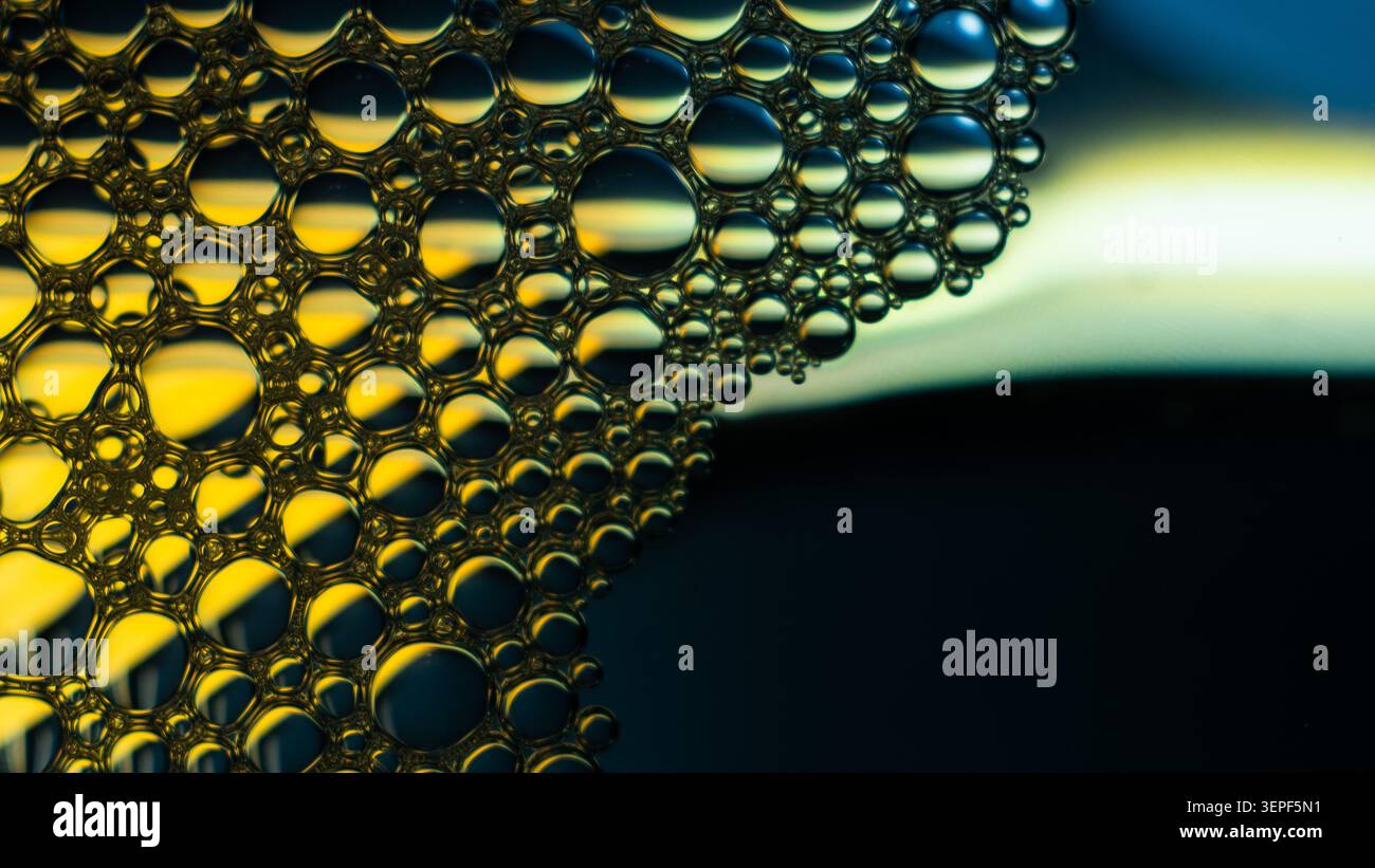 Liquid bubbles forming an abstract macro surface with golden highlights Stock Photo