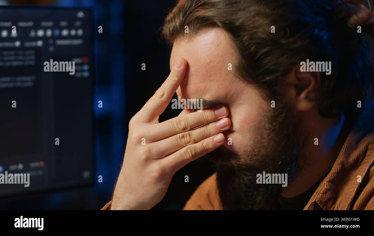 Disappointed computer scientist puzzled after being unable to remove all bugs while coding on workstation desktop. Teleworking IT specialist confused by troubling script errors. close up. Stock Photo