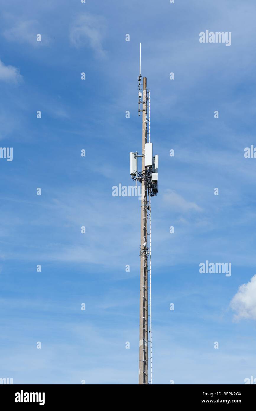 Telecommunication tower with antennas against blue sky Stock Photo