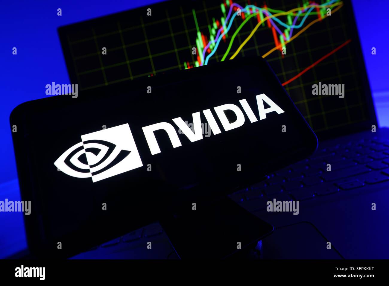 NVIDIA Logo on Smartphone Screen With Stock Market Performance Chart on Computer Stock Photo