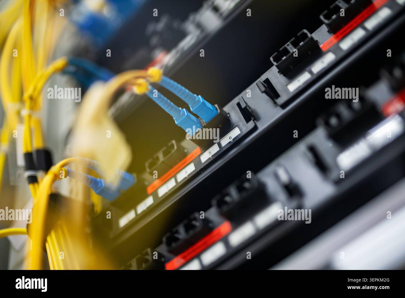 Fiber patch panel with connected optical cables in a server rack data center Stock Photo