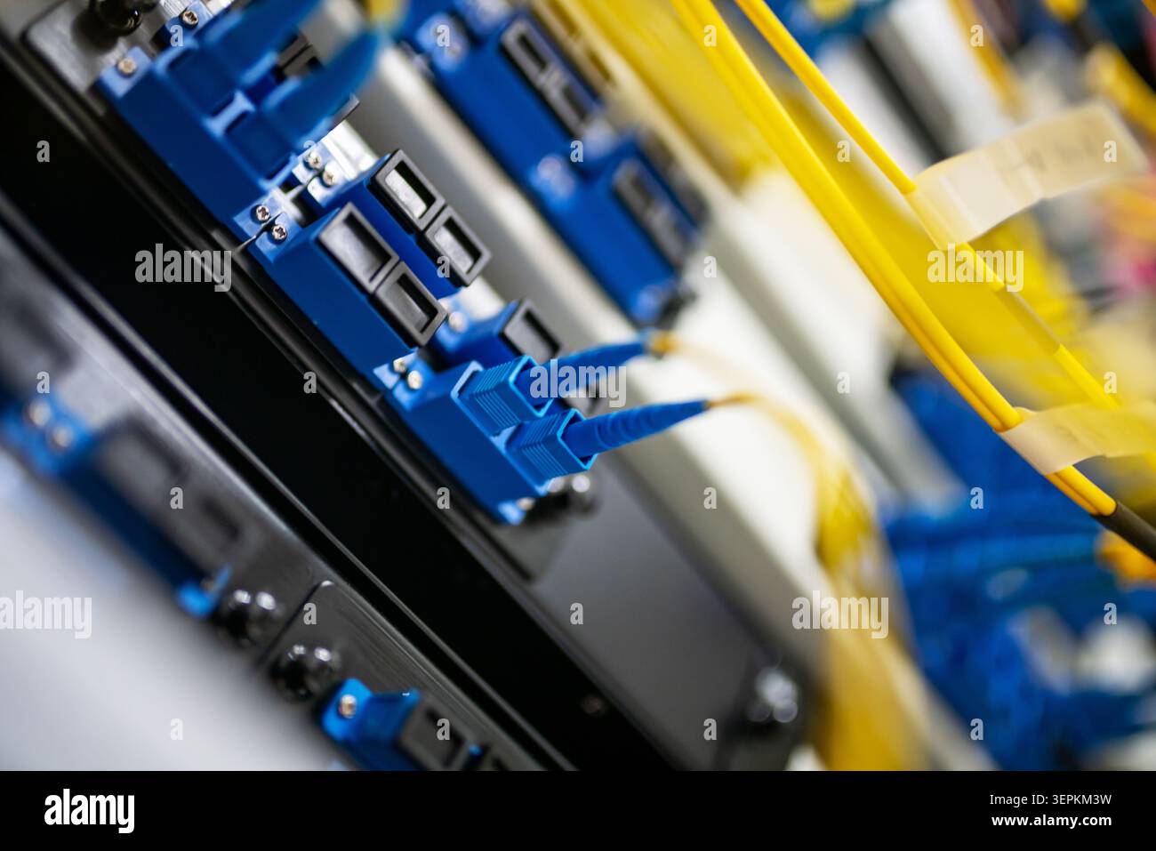 Fiber patch panel with connected optical cables in a server rack data center Stock Photo