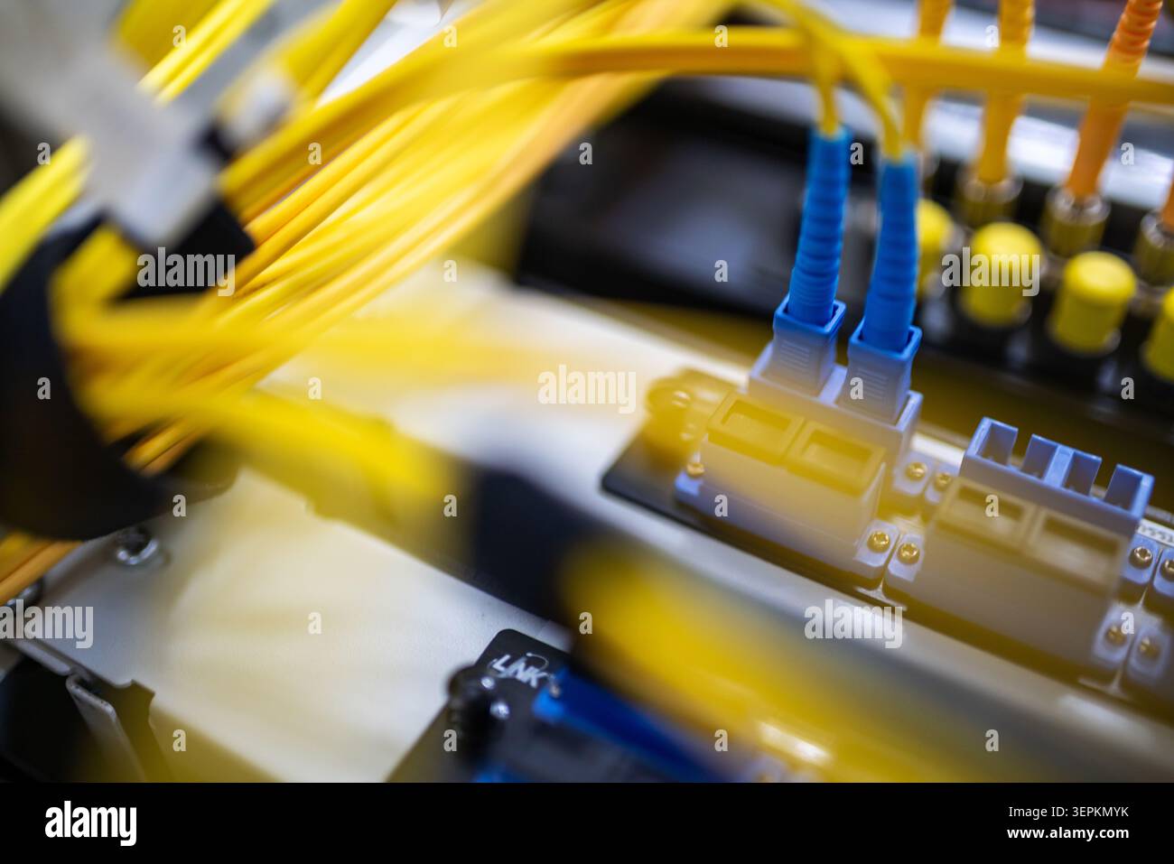 Fiber patch panel with connected optical cables in a server rack data center Stock Photo