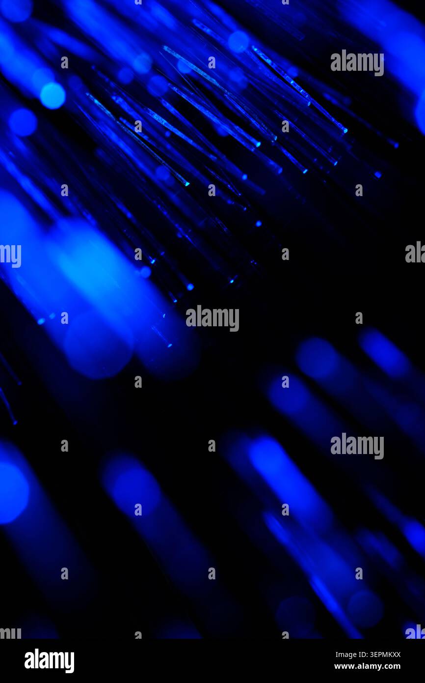 Dynamic blue fiber optic cables with sharp details and blurred light elements in dark Stock Photo