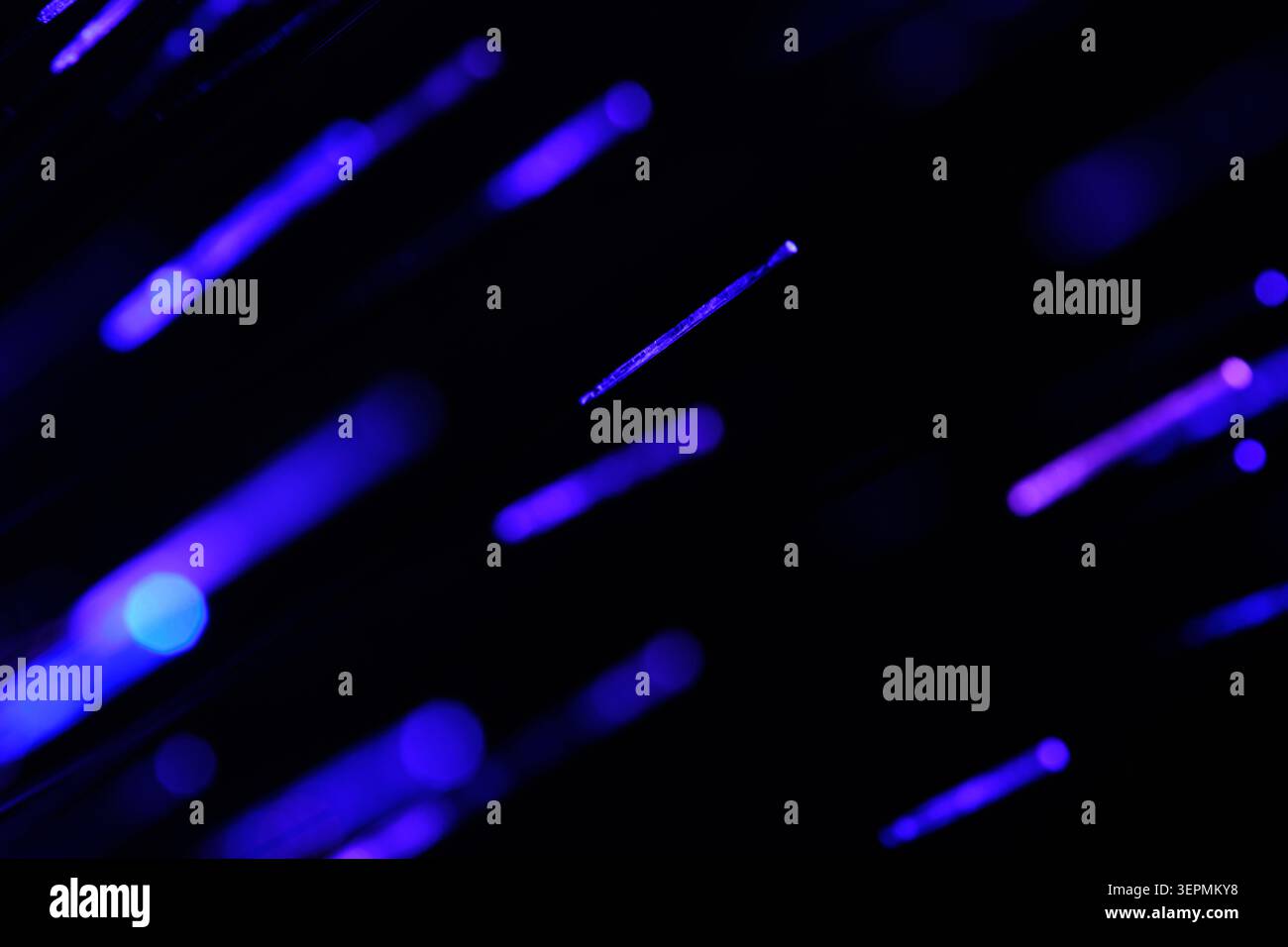 Sparse glowing blue and purple light dashes scattered across deep dark texture background Stock Photo