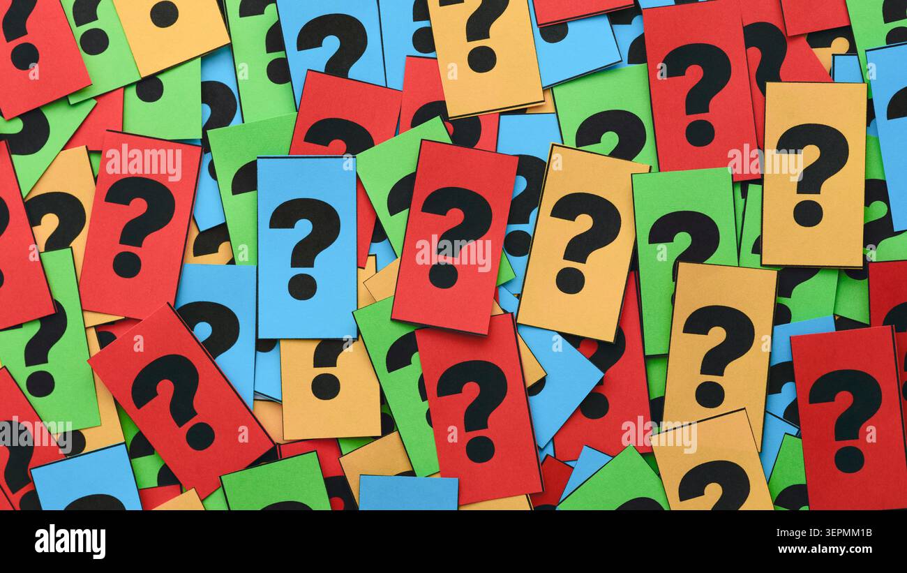 A background filled with a scattered pile of colorful notes featuring black question marks. Close up. Stock Photo
