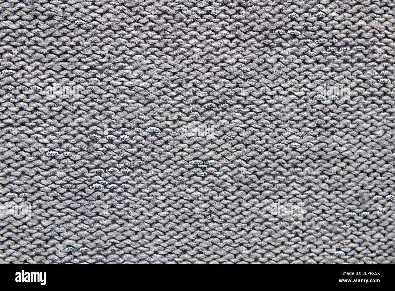 Gray knitted fabric texture close-up with repeating stitch pattern and soft woolen look Stock Photo