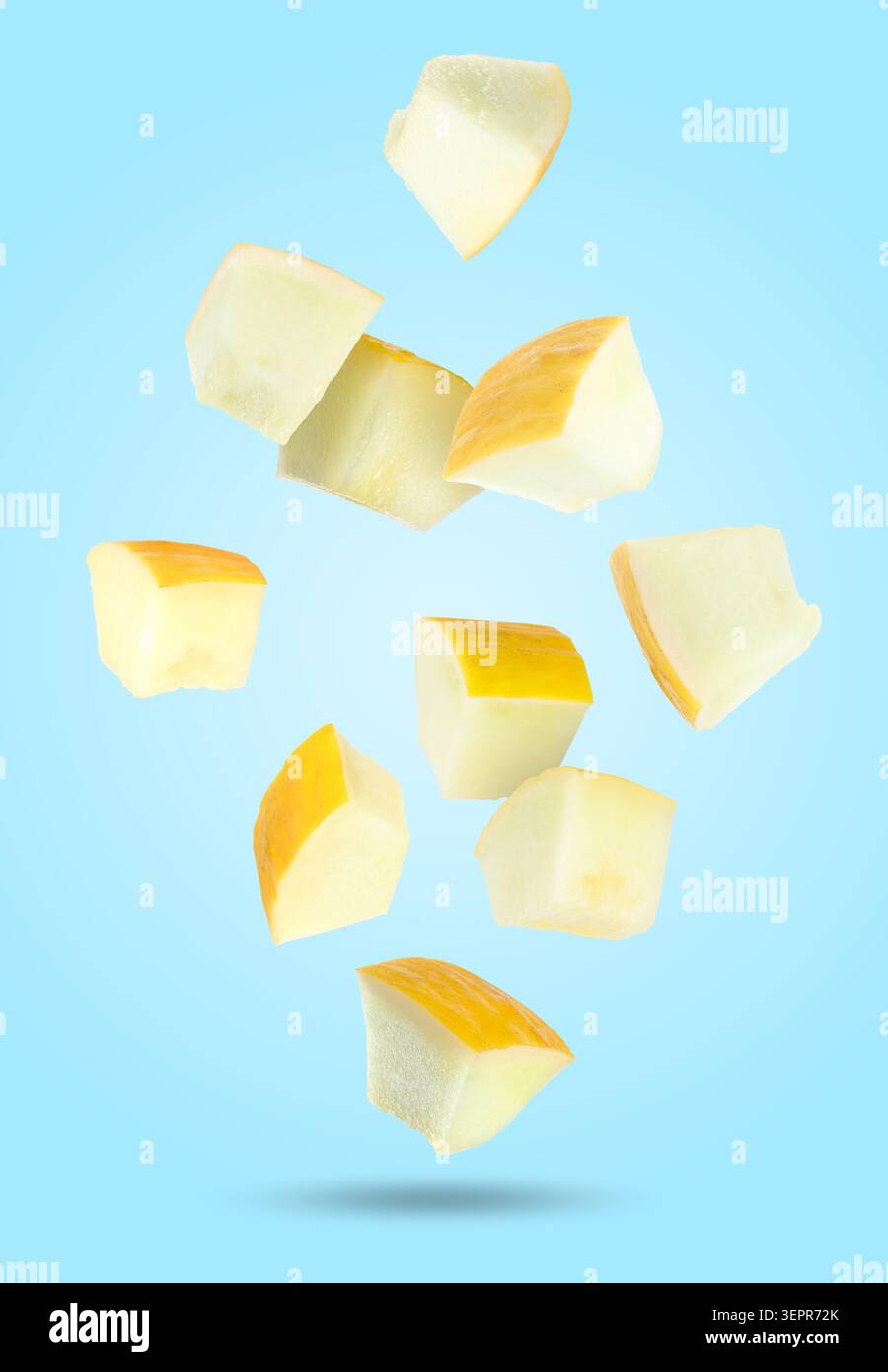 Sweet melon pieces falling against light blue background Stock Photo