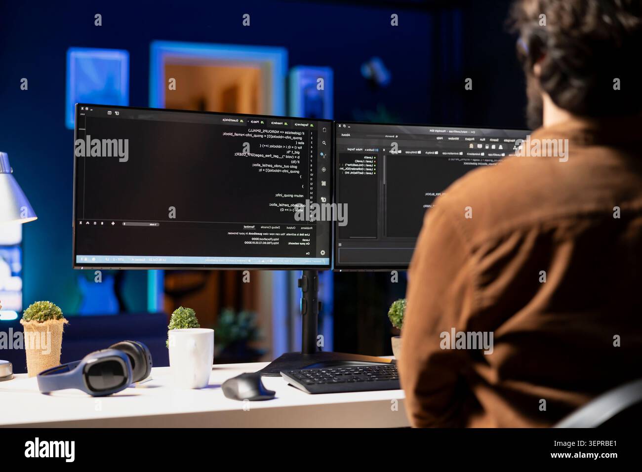 Man working from home implementing security measures to protect company systems and data; tech support IT worker writing, testing and debugging code for software applications. Stock Photo