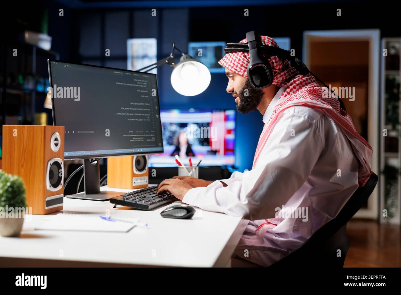 Middle Eastern software programmer typing code on a laptop showcasing the essence of software programming and development while arab man with wireless headphones engrossed in running algorithms. Stock Photo