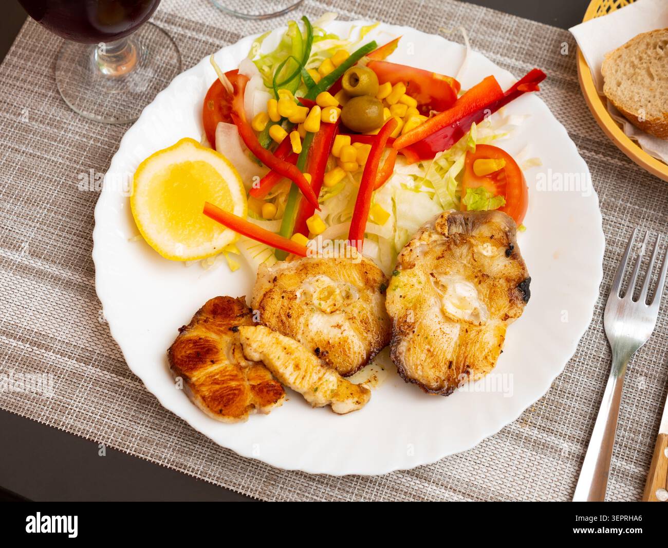 Oven baked hake with vegetable garnish Stock Photo