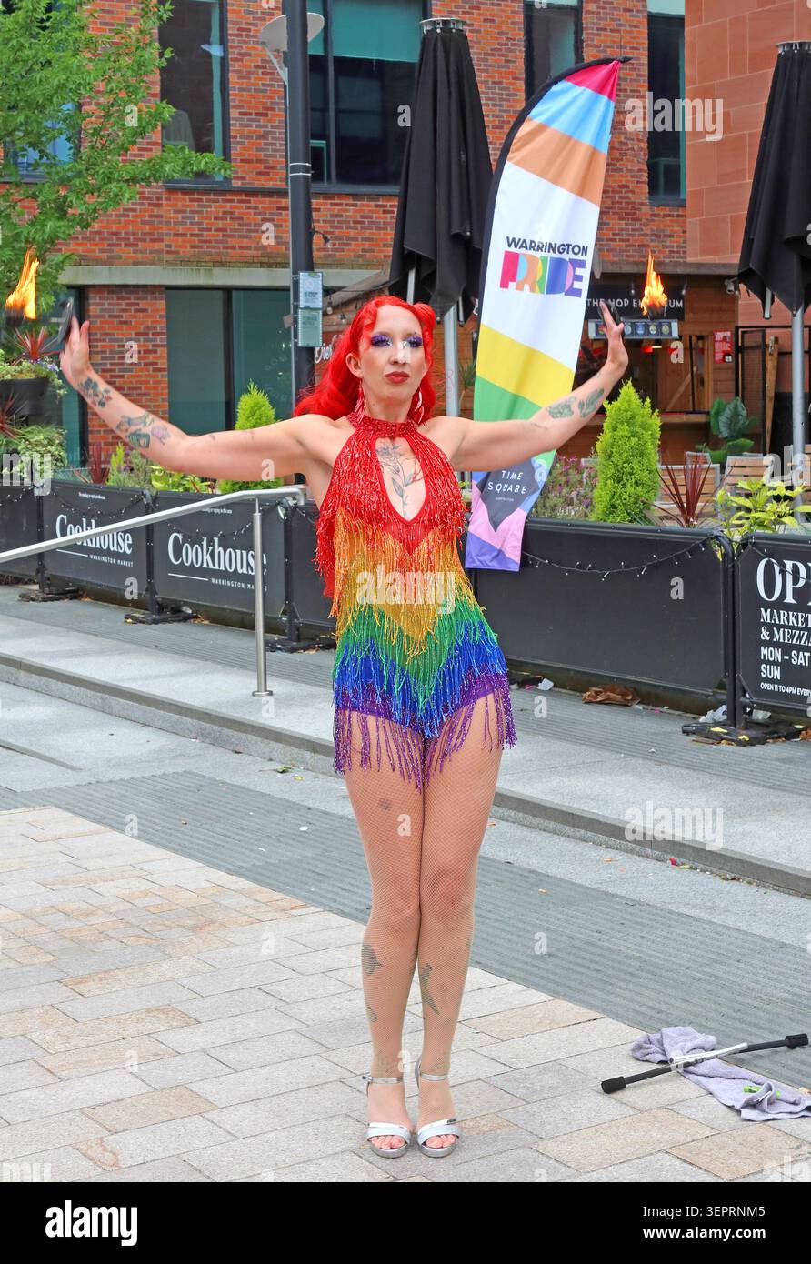 Fire eater in rainbow costume performing at Warrington Pride 2026 in Time Square , Warrington, Cheshire, England, UK WA1 2NT Stock Photo
