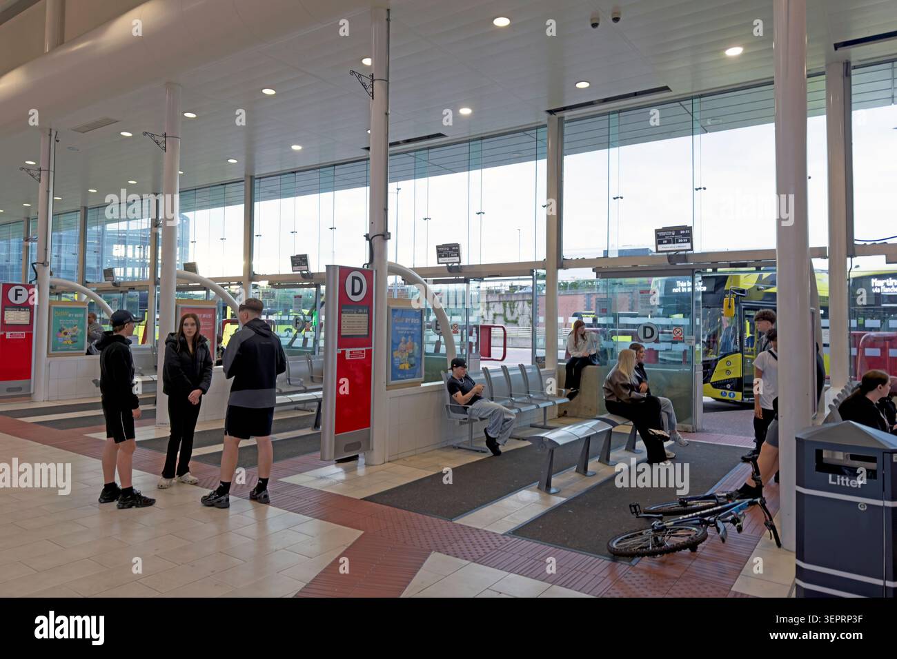 Passengers wait for early evening bus services inside Warrington Bus Interchange in the town centre, Cheshire, England, UK. Stock Photo