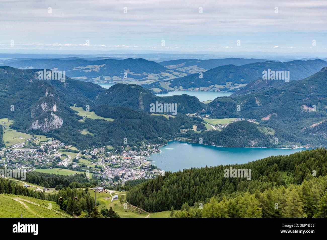 Panoramic view from the Zwölferhorn (1,522 m above sea level) over the village of Sankt Gilgen, Lake Wolfgang and the lake district of the Salzkammergut; Lake Mondsee can be seen in the background. The Zwölferhorn can be reached by gondola lift from Sankt Gilgen and offers one of the most sweeping views of the Salzkammergut. Sankt Gilgen, Salzburg, Austria Stock Photo