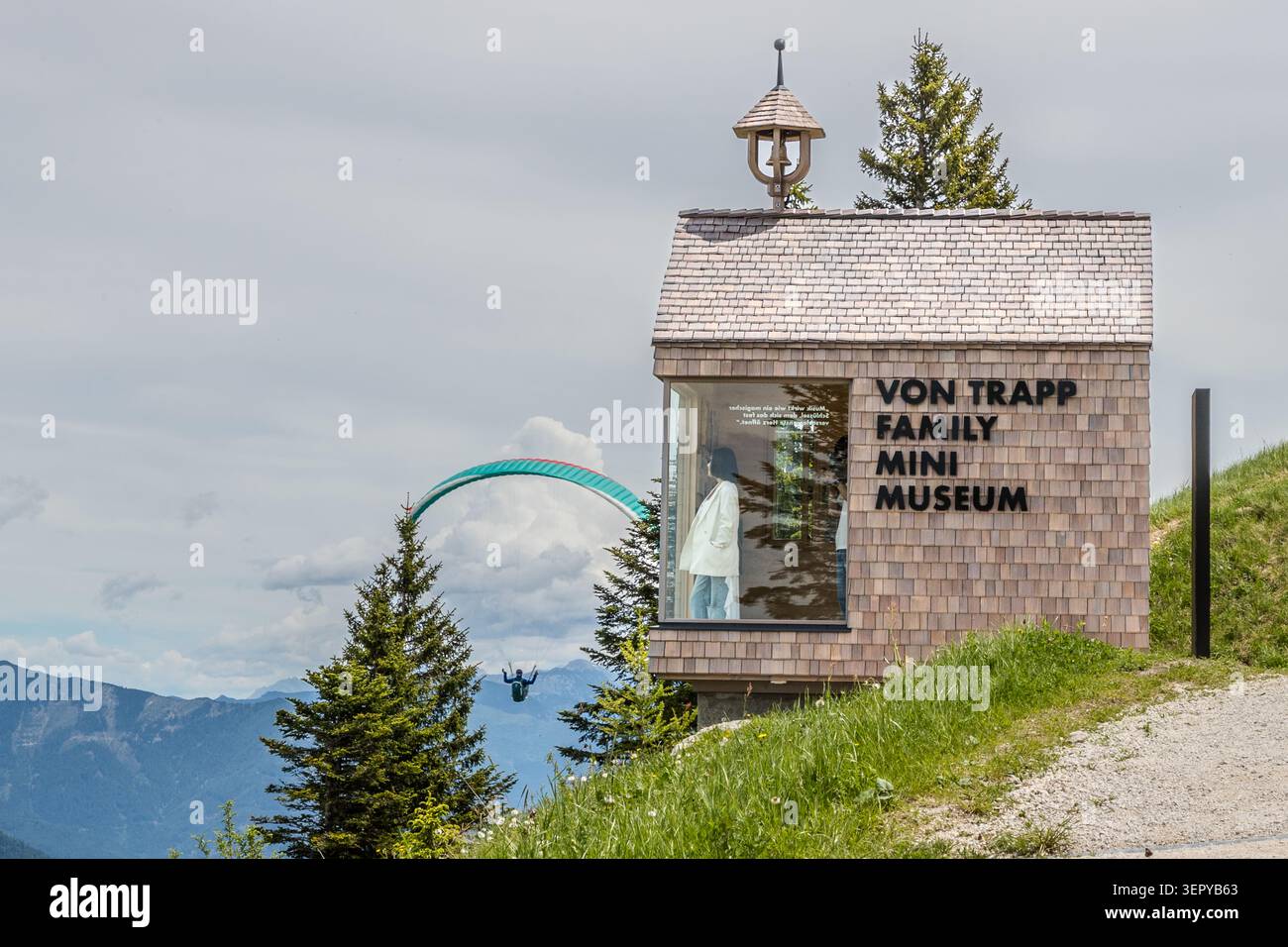 The ‘Von Trapp Family Mini Museum’ on the Zwölferhorn (1,522 m) above Sankt Gilgen; in the background on the left, a paraglider soars over the Salzkammergut. Opened at Whitsun 2026, the Mini Museum commemorates the history of the von Trapp family, who emigrated from Austria in 1938 and whose story served as the inspiration for *The Sound of Music*. Sankt Gilgen, Salzkammergut, Salzburg, Austria Stock Photo