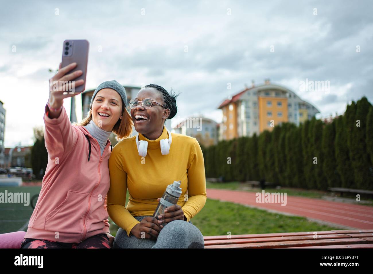 Diverse friends taking selfie celebrating friendship outdoors Stock Photo