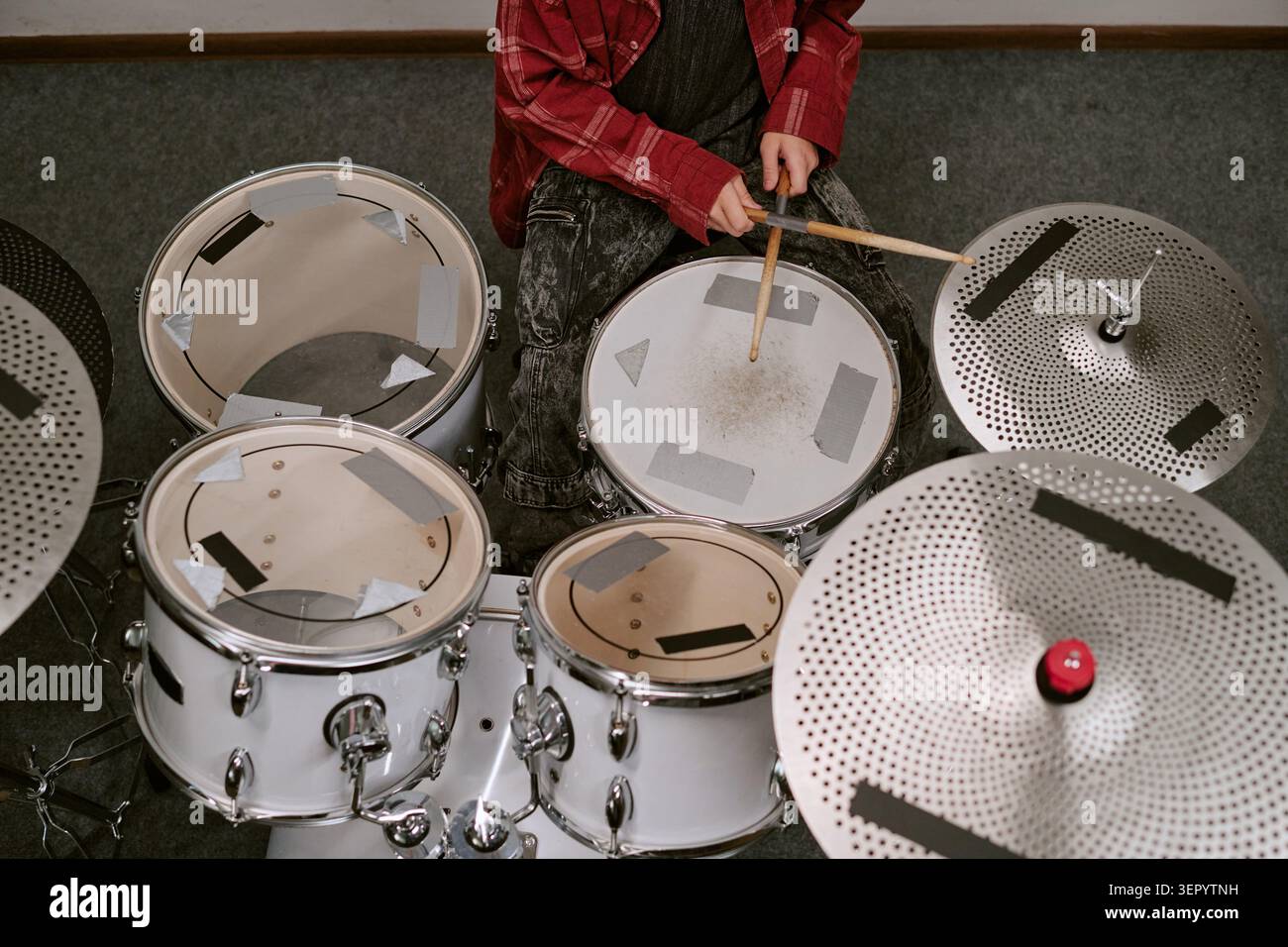 Teenager Practicing Drum Kit Technique for Music Training Program Stock Photo