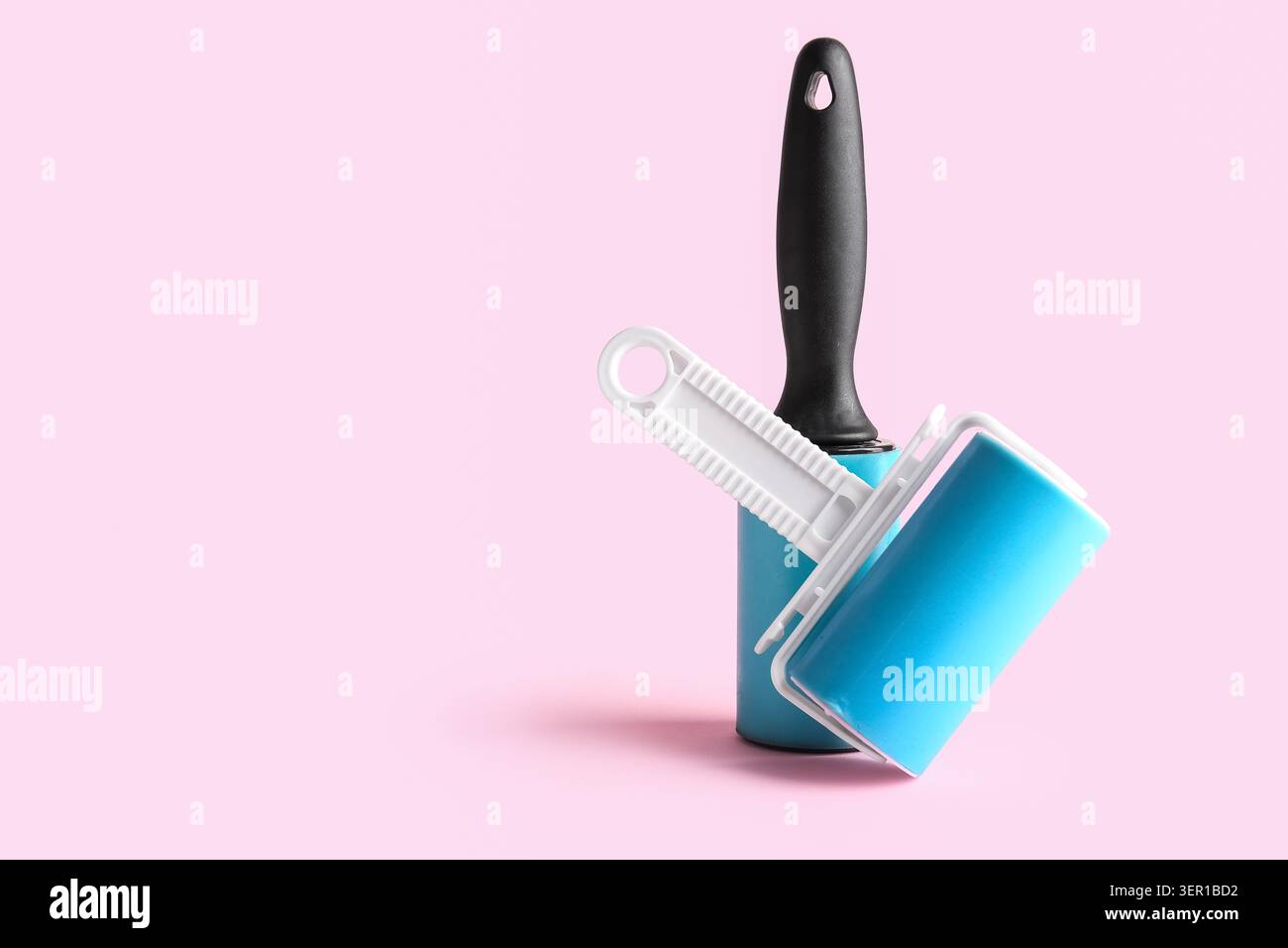 Different lint rollers on pink background Stock Photo
