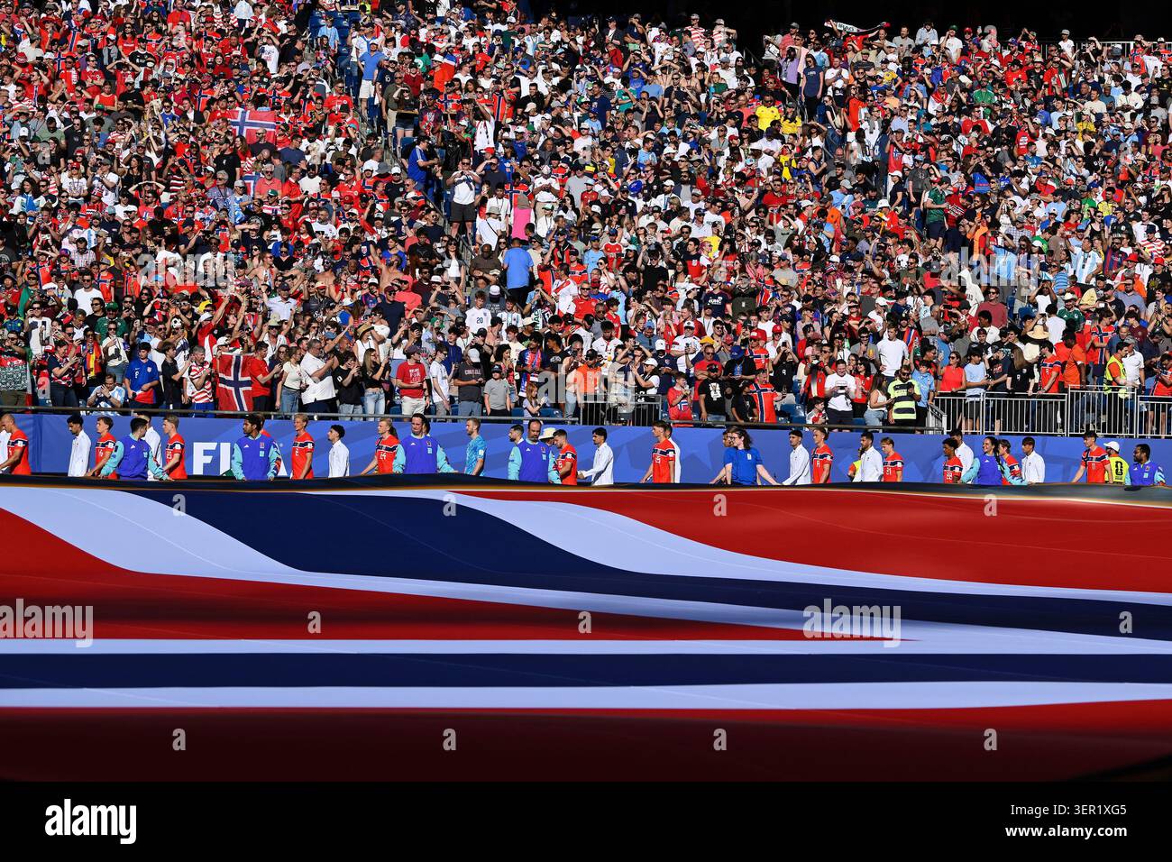 Members Of Team Norway Parade By A Norwegian Flag Before The Start Of A members-of-team-norway-parade-by-a-norwegian-flag-before-the-start-of-a