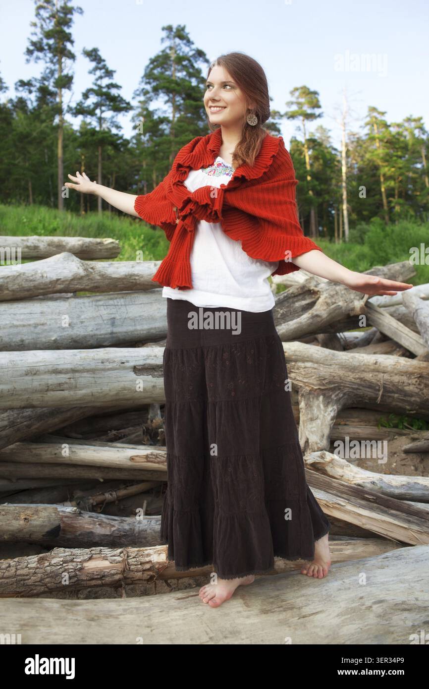 Young pretty woman balancing on logs in the forest Stock Photo