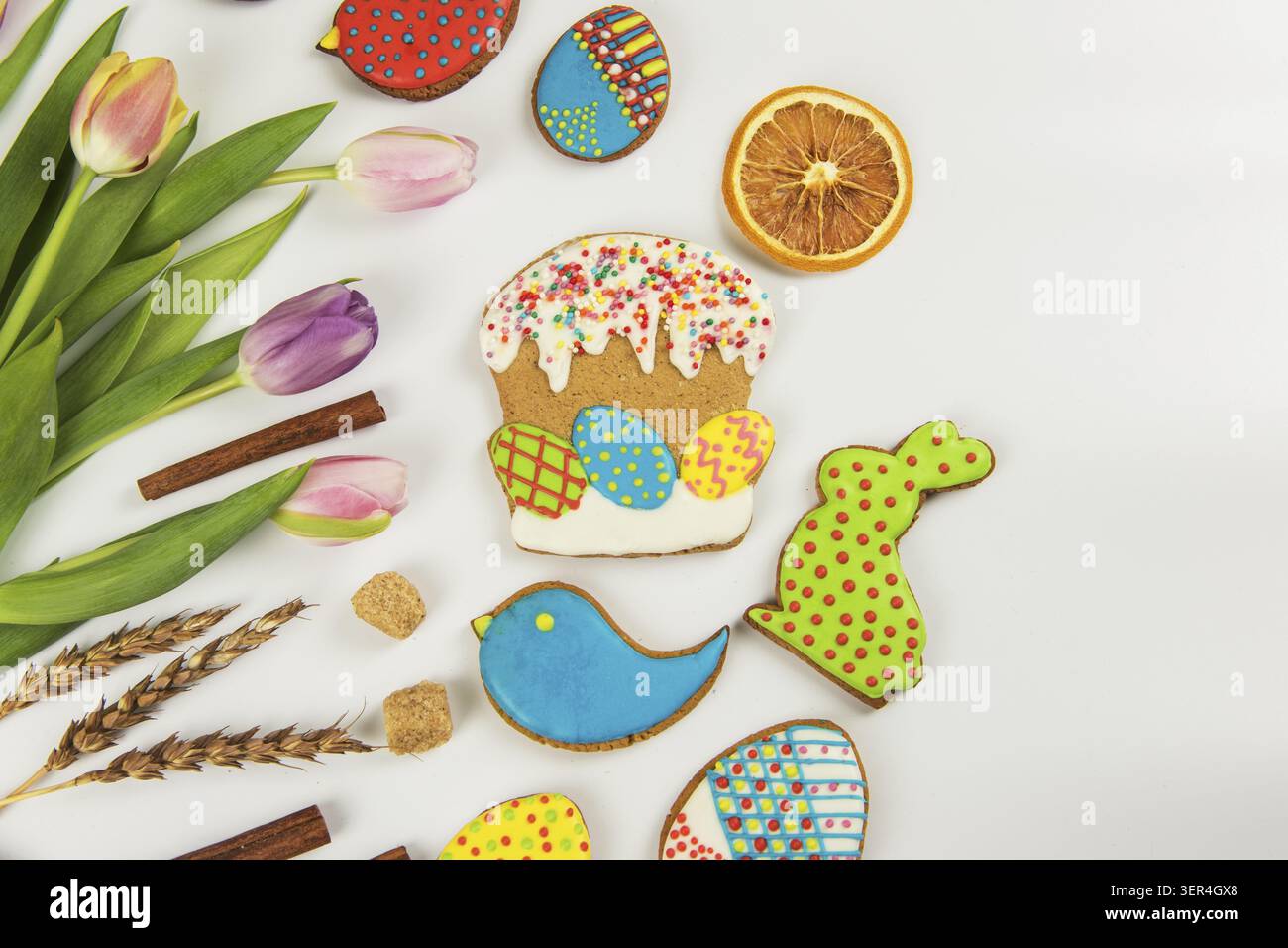 Tulips and gingerbread cookies on white background for Easter Stock Photo