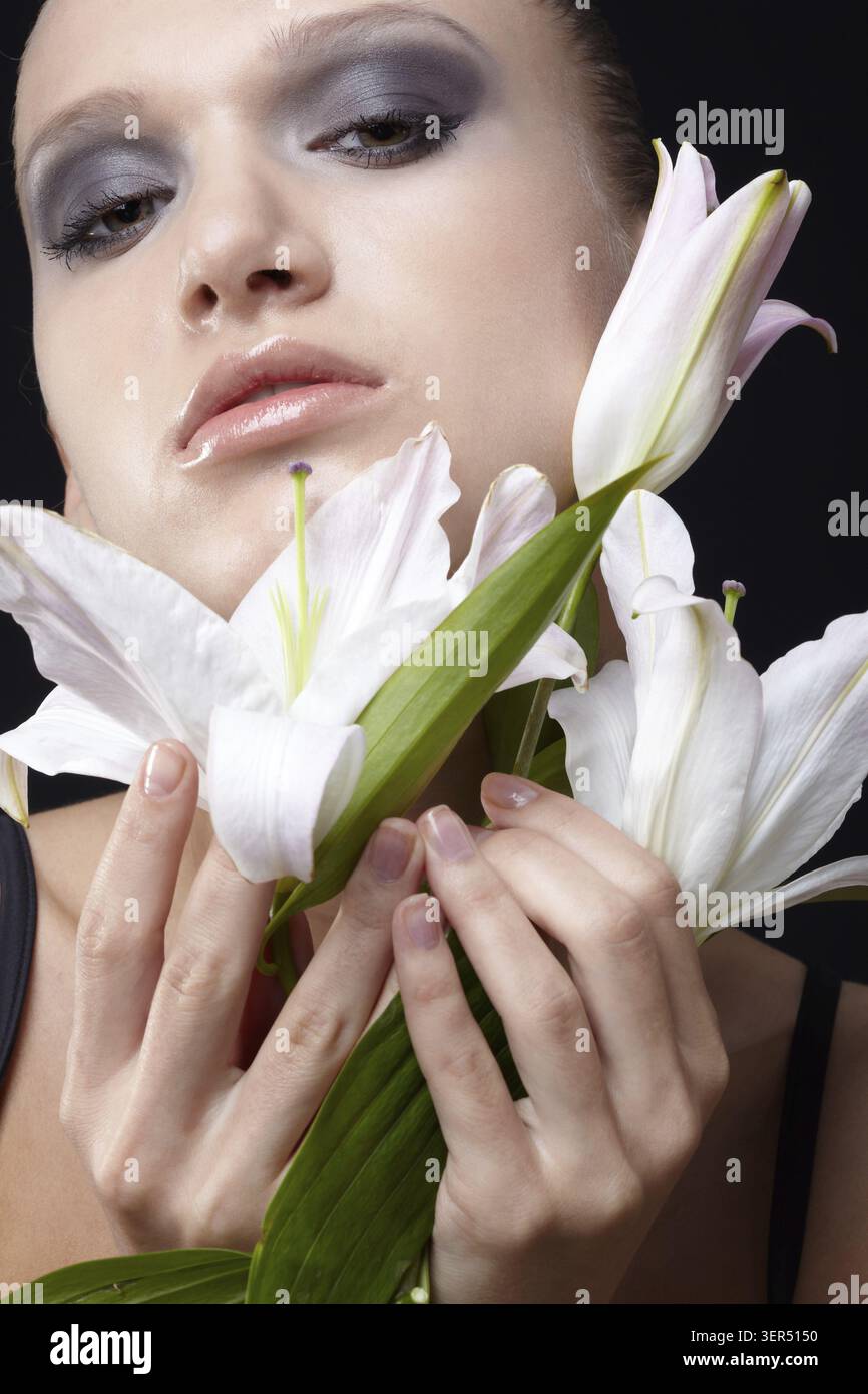 Portrait of beautiful dark haired slavonic model posing with flower Stock Photo