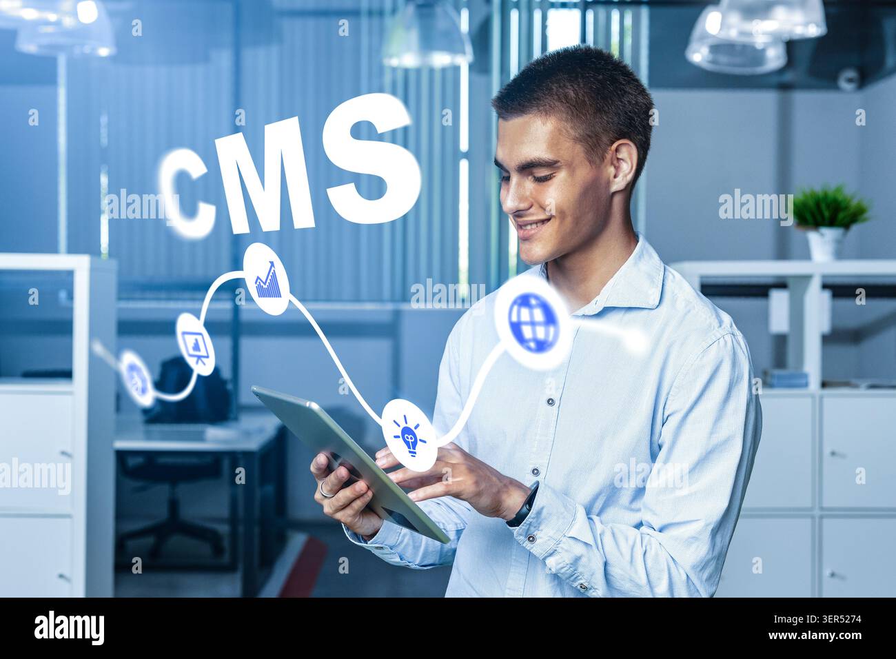 Young man using a tablet in an office setting for content management system tasks Stock Photo