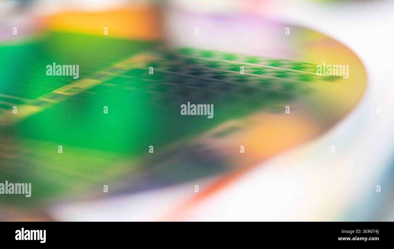 Silicon wafer reflecting iridescent colors and abstract microchip patterns Stock Photo