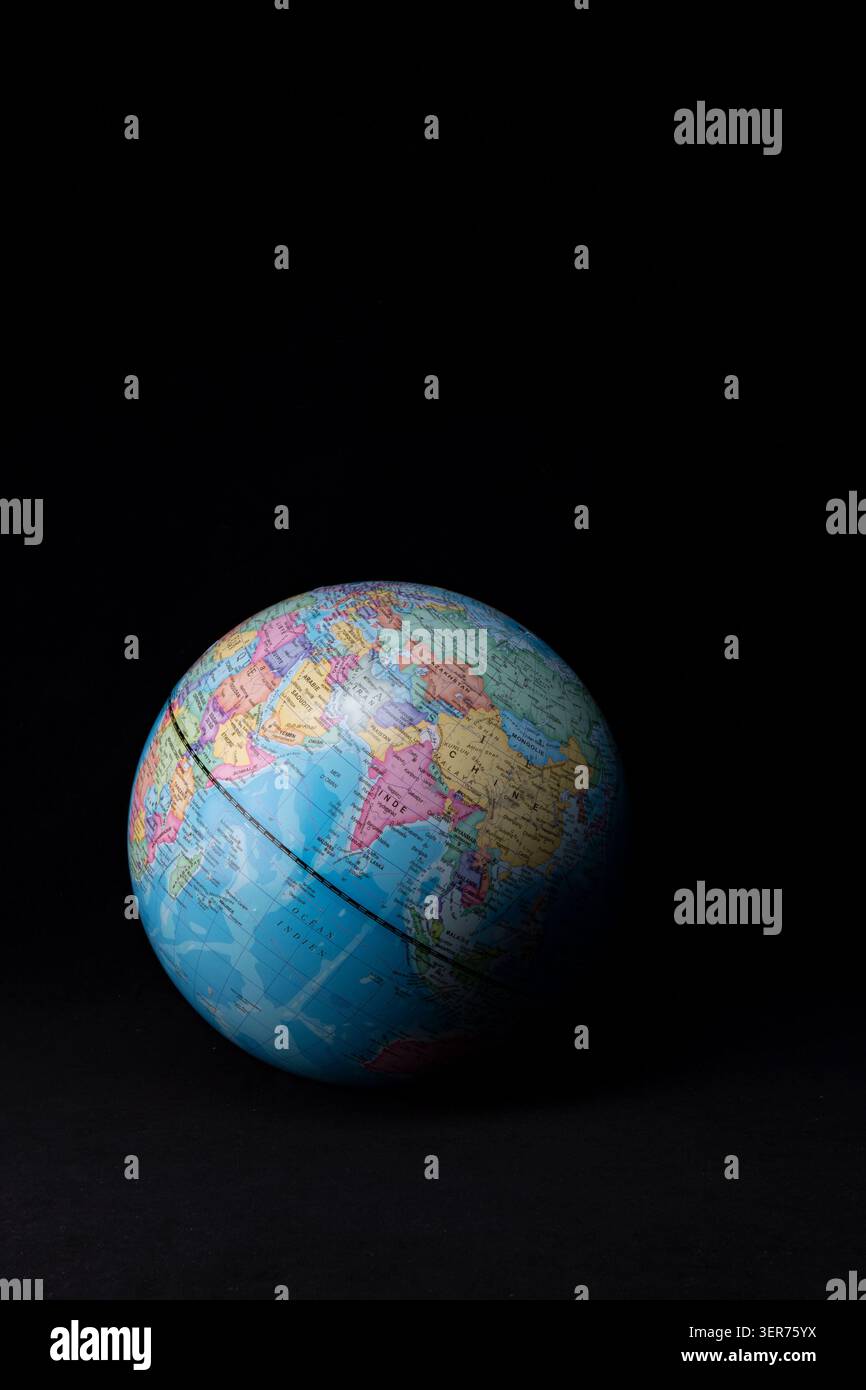 Globe displaying continents and oceans on black background Stock Photo