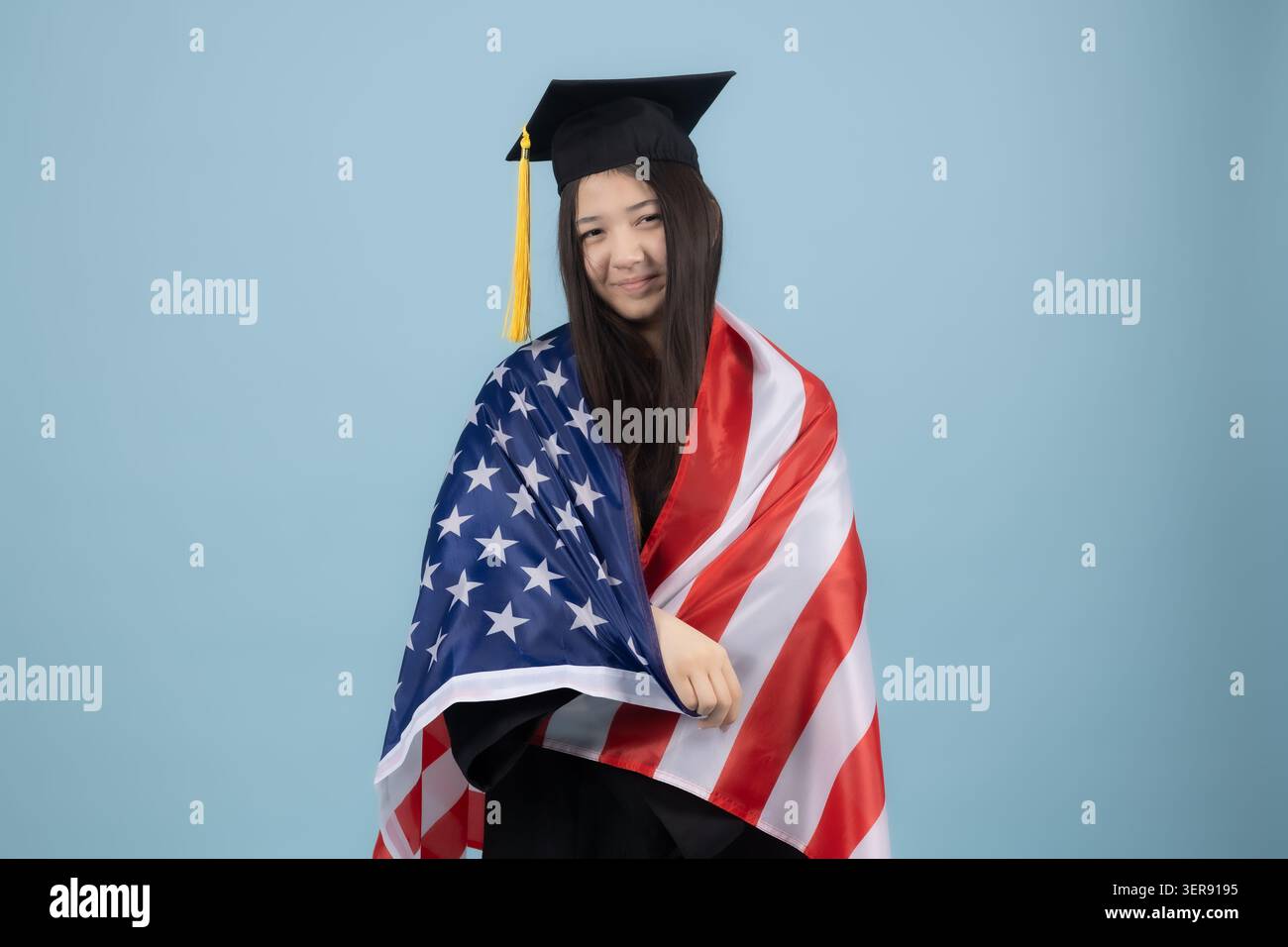 Graduate holding an American flag Stock Photo