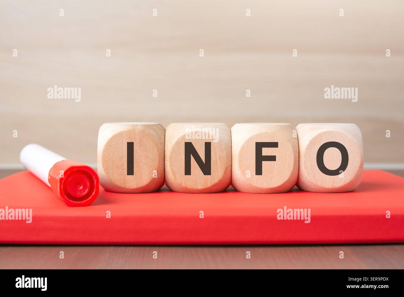 Wooden cubes with INFO text on a red notebook. Stock Photo