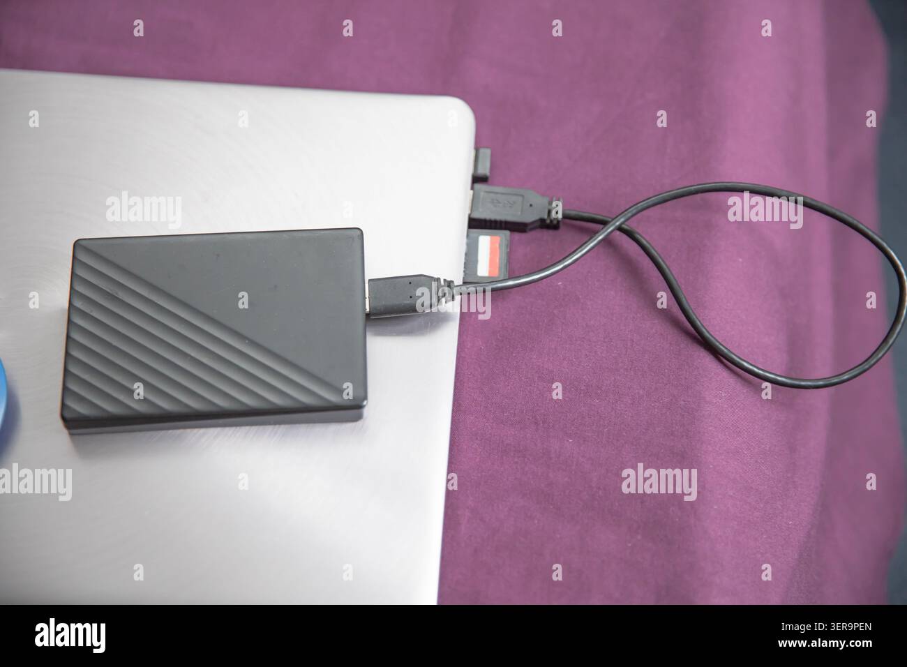 External portable hard drive connected to laptop for secure data backup storage Stock Photo