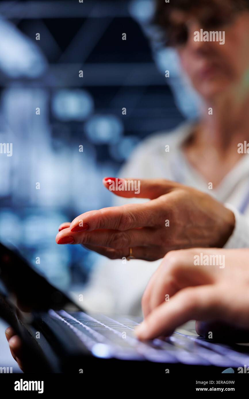 Colleagues performing diagnostic assessments on mainframes to detect problems with server room units. Coworkers crosschecking maintenance lists, looking for potential system concerns, close-up. Stock Photo