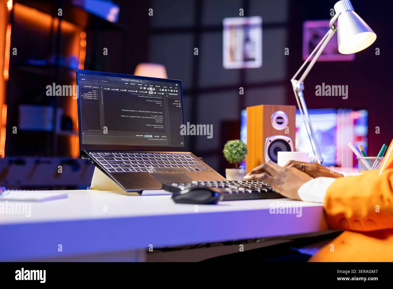 Engineer at desk typing code on notebook device, developing software programs, entering commands. Person at home fixing errors in application, implementing new features, close-up. Stock Photo
