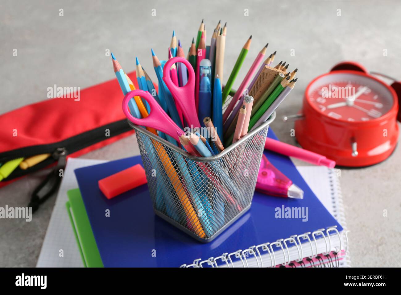 Pencil holder and notebooks on grey background Stock Photo