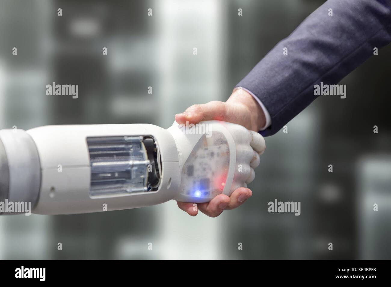 Robotic arm shakes hands with its partner Stock Photo