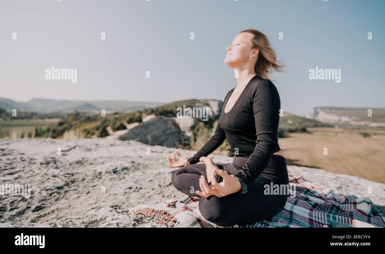 Woman Meditating on a Mountaintop Stock Photo